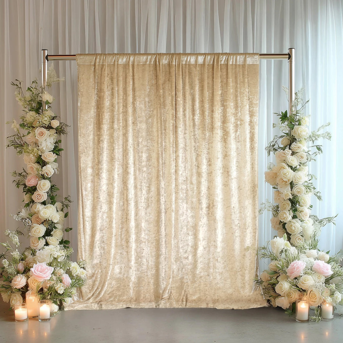 Elegant beige velvet backdrop with floral arrangements and candles.