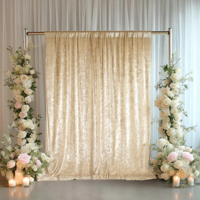 Elegant beige velvet backdrop with floral arrangements and candles.