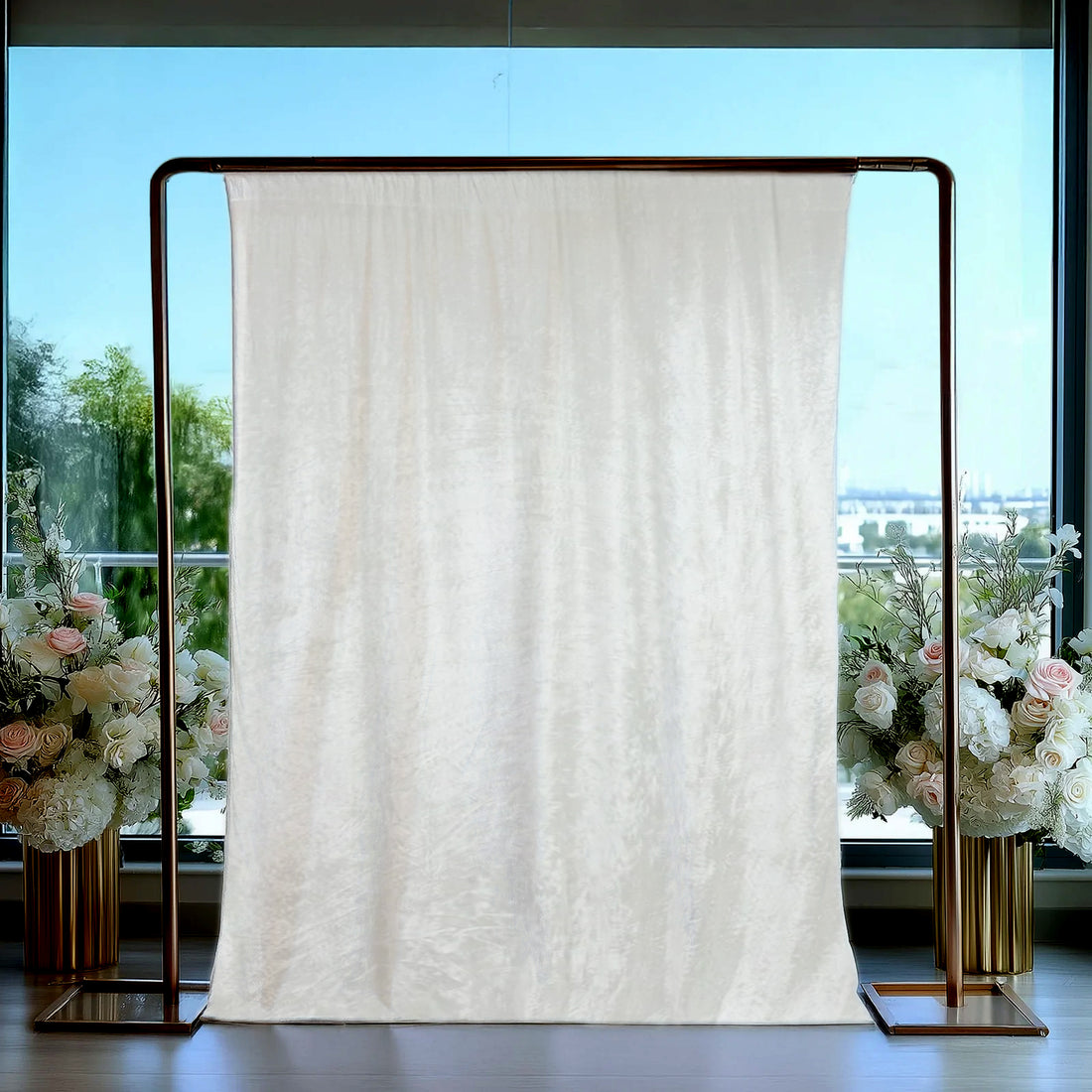 Elegant cream backdrop with floral arrangements in stylish vases.