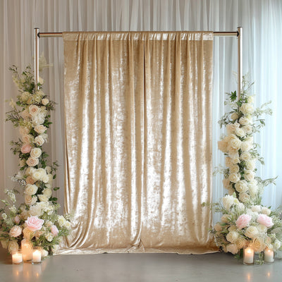 Elegant gold velvet backdrop with floral arrangements and candles.