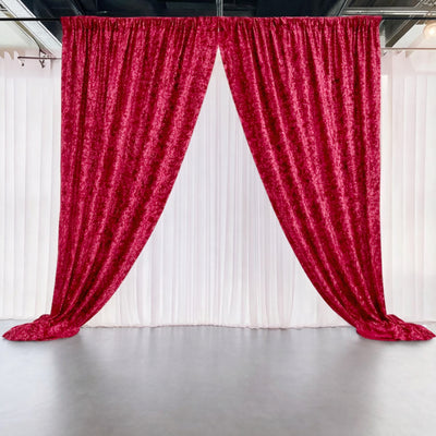 Red velvet curtains on a white backdrop in a studio setting.