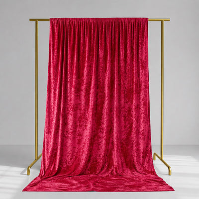 Red velvet backdrop curtain on gold frame stand in studio setting