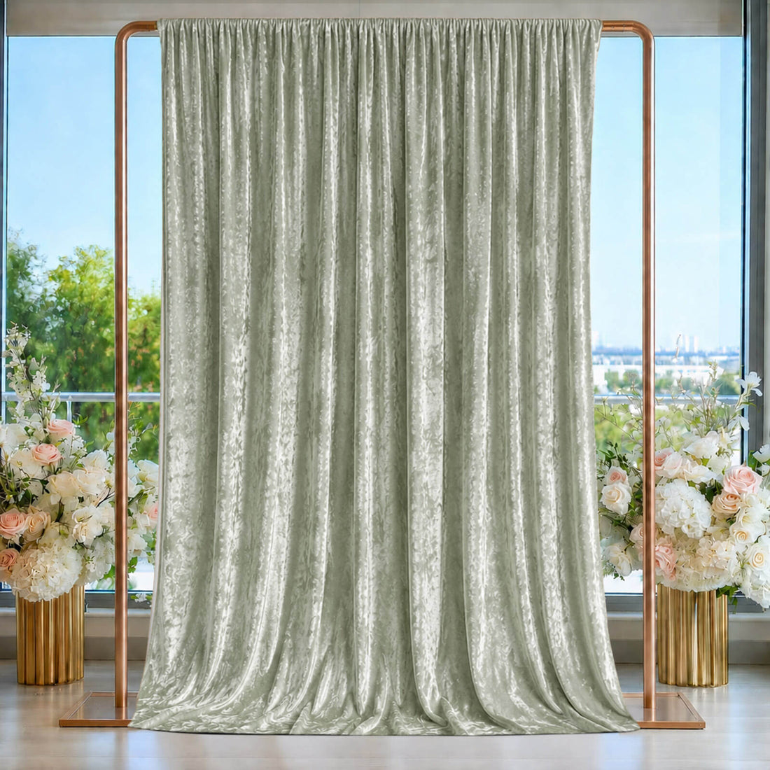 Elegant sage green velvet drape on copper frame with floral decor and window backdrop