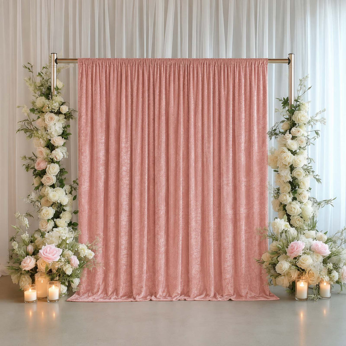 Pink wedding backdrop with floral pillars and candles