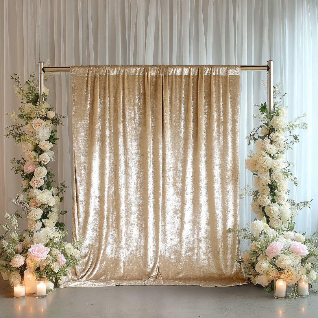Elegant gold velvet backdrop with floral arrangements and candles for events.