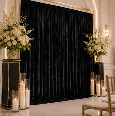 Elegant black velvet wedding backdrop with white floral arrangements and candles