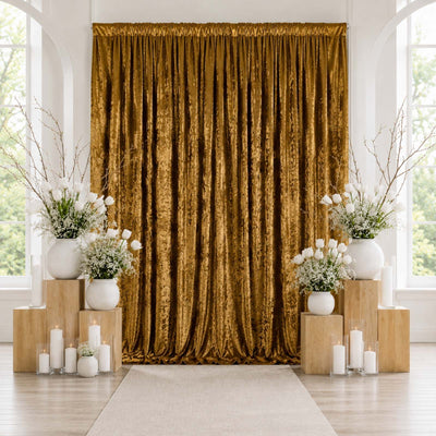 Elegant gold velvet curtain backdrop with white floral arrangements and candles