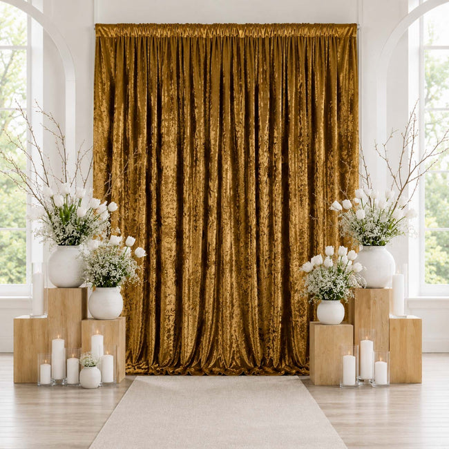 Elegant gold velvet curtain backdrop with white floral arrangements and candles