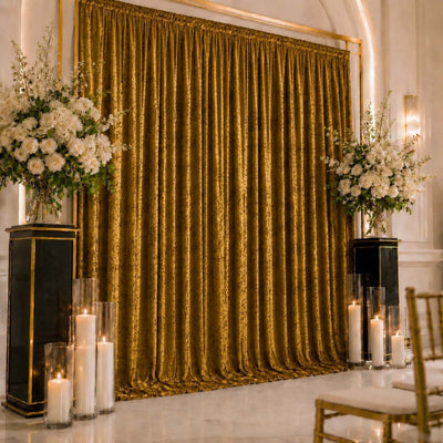 Elegant gold wedding backdrop with white floral arrangements and candle decor