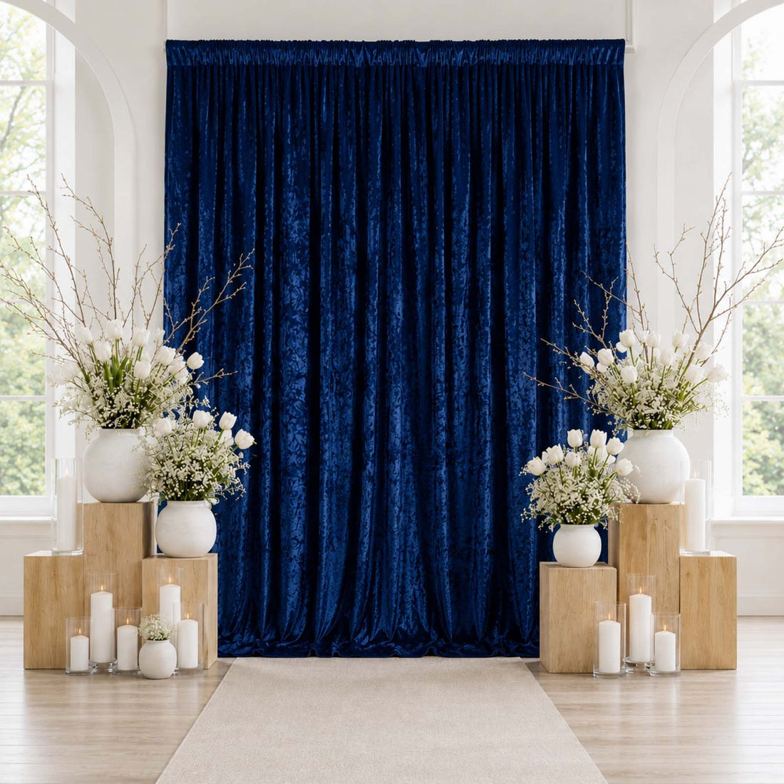 Elegant navy blue velvet curtain backdrop with white floral and candle decor