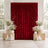 Red velvet wedding backdrop with white floral arrangements and candles