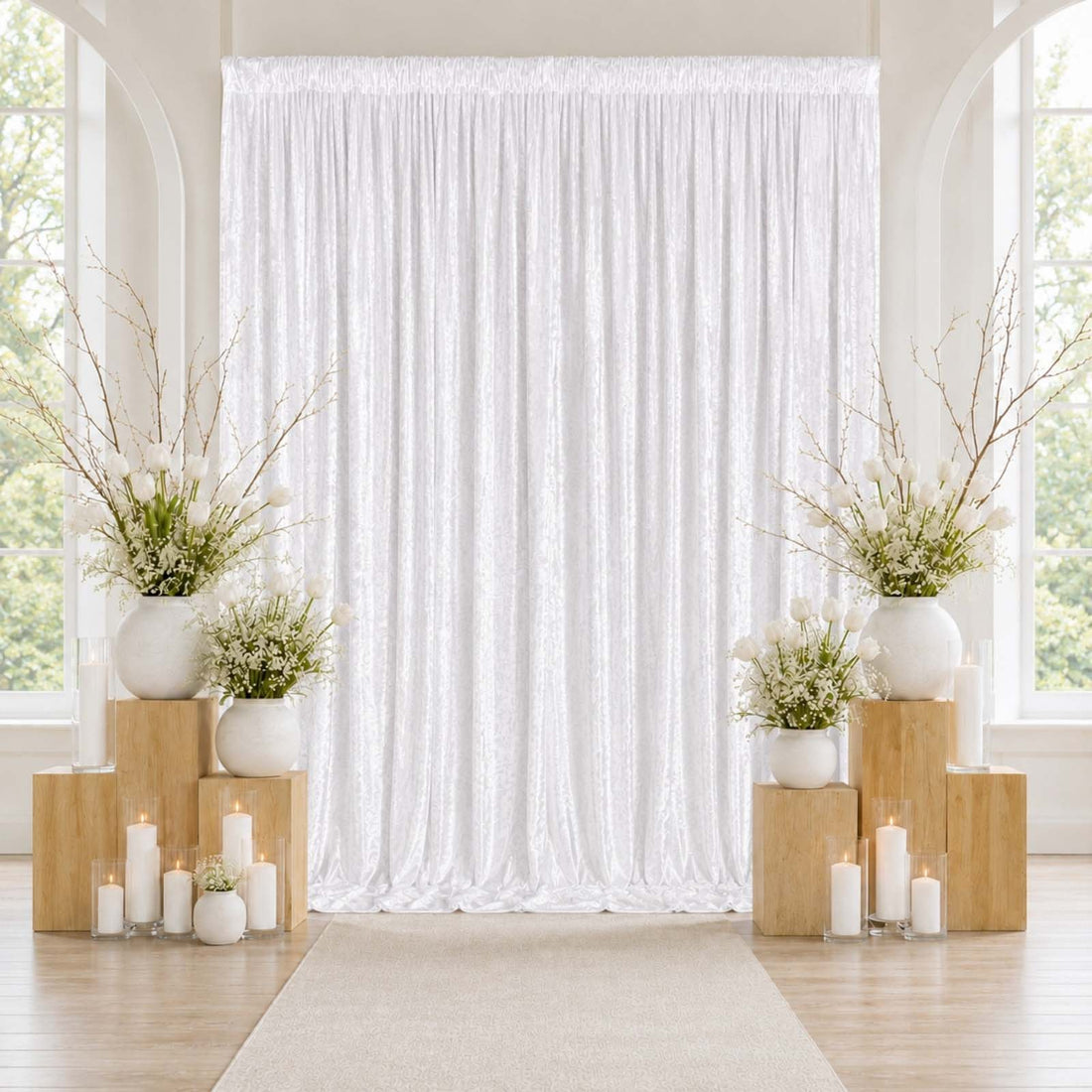 Elegant white wedding backdrop with floral arrangements and candles
