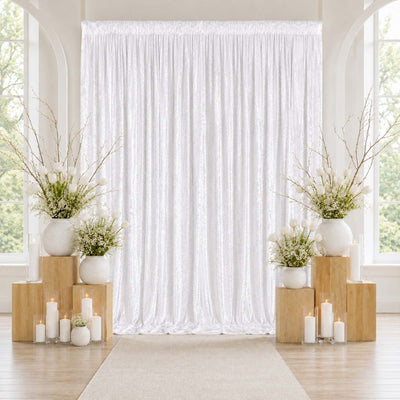 Elegant white wedding backdrop with floral arrangements and candles