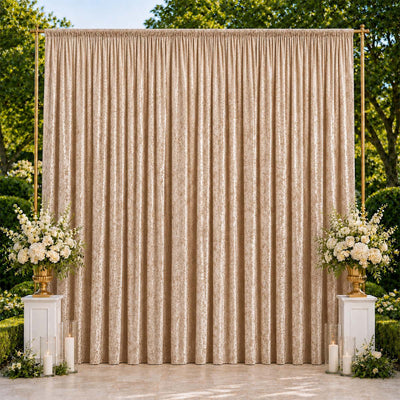 Elegant gold wedding backdrop with floral arrangements and candles outdoors