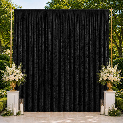 Elegant black velvet event backdrop with white floral arrangements and candles