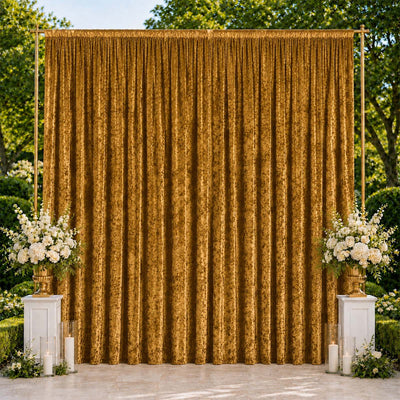Gold wedding backdrop with curtains, white floral arrangements, and candles