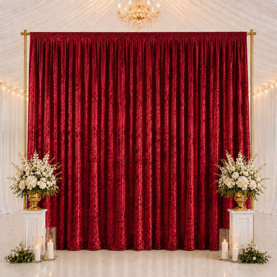 Elegant red velvet backdrop with gold frame, white floral arrangements, and candles