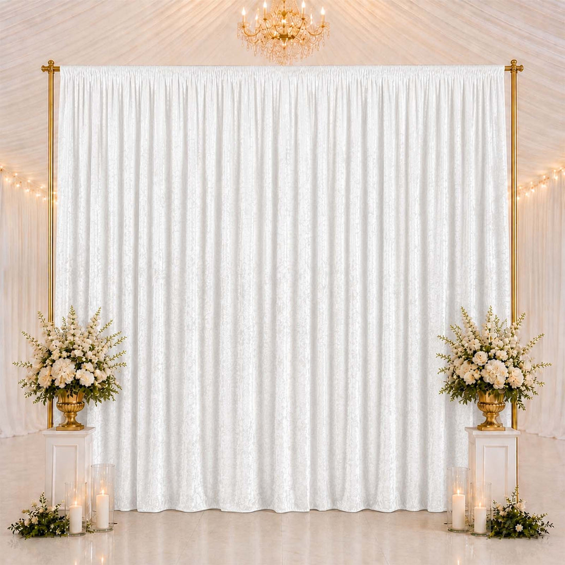 Elegant wedding backdrop with white drapes, gold frame, and floral arrangements