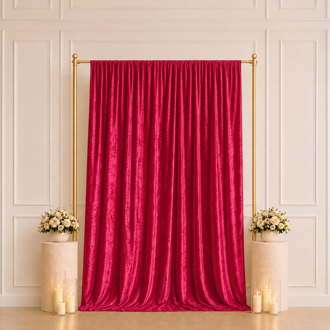 Elegant red velvet backdrop with gold frame, floral arrangements, and candles