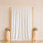 Elegant wedding backdrop with white drape, gold frame, roses, and candles