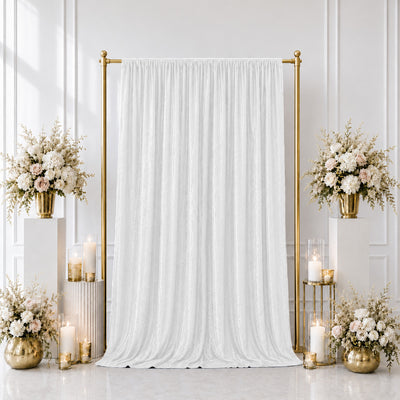 Elegant white wedding backdrop with gold stands, floral arrangements, and candles