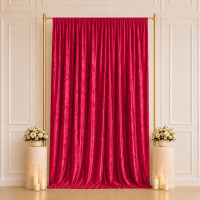 Elegant red velvet curtain with gold frame, floral pedestals, and candles