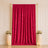 Elegant red velvet curtain with gold frame, floral pedestals, and candles
