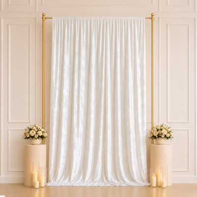 Elegant white wedding backdrop with gold frame, floral arrangements, and candles