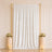 Elegant white wedding backdrop with gold frame, floral arrangements, and candles