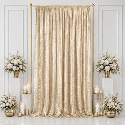 Elegant gold wedding backdrop with champagne drape, white florals, and candles