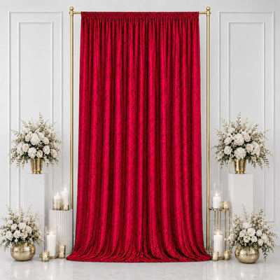 Elegant red velvet curtain backdrop with white floral arrangements and gold accents