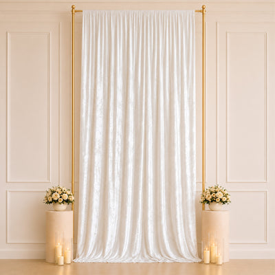 Elegant white wedding backdrop with gold frame, floral arrangements, and candles