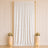 Elegant white wedding backdrop with gold frame, floral arrangements, and candles