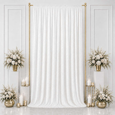 Elegant white wedding backdrop with gold stands, floral arrangements, and candles