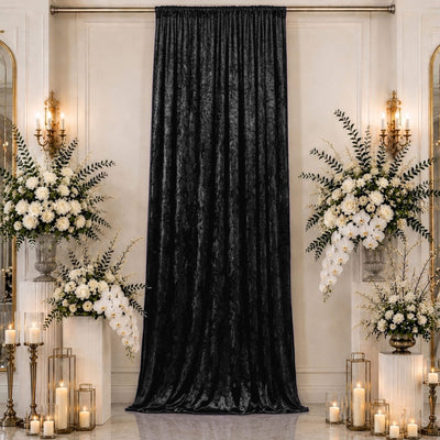 Elegant black velvet curtain with white floral wedding ceremony decor and candles