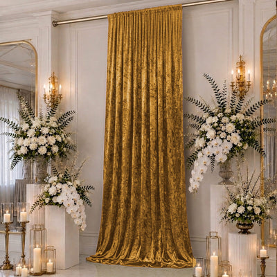 Elegant gold velvet curtain with white floral arrangements in a luxe interior.