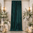 Elegant wedding backdrop with emerald velvet drape, white floral arrangements, and candles