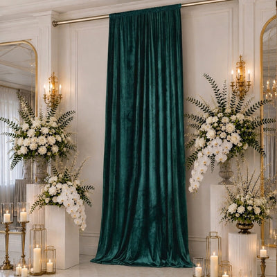 Elegant emerald velvet backdrop with white floral arrangements and gold candle decor