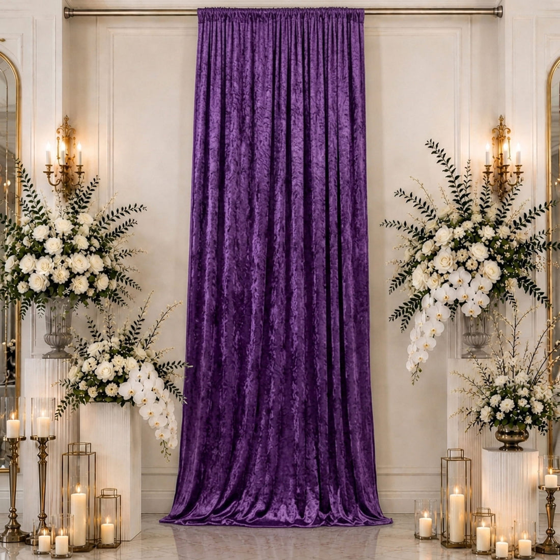 Purple velvet wedding backdrop with white floral arrangements and candles