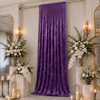 Purple velvet wedding backdrop with white floral arrangements and candles
