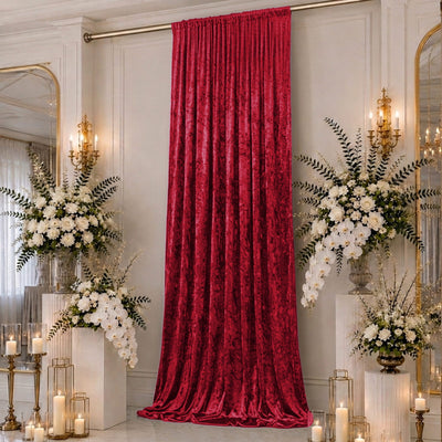 Elegant red velvet curtain with white floral arrangements in a luxury event room