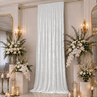 Elegant white floral wedding backdrop with draped curtain and gold candles