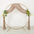 Gold circular wedding arch with draped blush velvet and floral arrangements