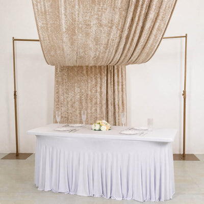 Elegant wedding sweetheart table with white linens and champagne drapery
