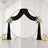 Elegant wedding backdrop with black drapery, gold circle arch, and white florals