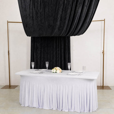 Elegant black draped wedding backdrop with white table and gold frame
