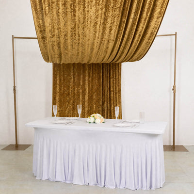 Elegant gold draped wedding backdrop with white table and floral centerpiece