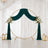 Elegant wedding backdrop with emerald drapes, gold circle arch, and floral accents