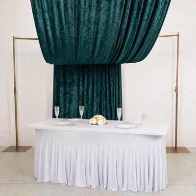 Elegant wedding table with white linens and teal velvet drapes behind it