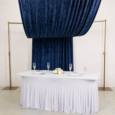 Elegant wedding sweetheart table with navy velvet drape and white table linens